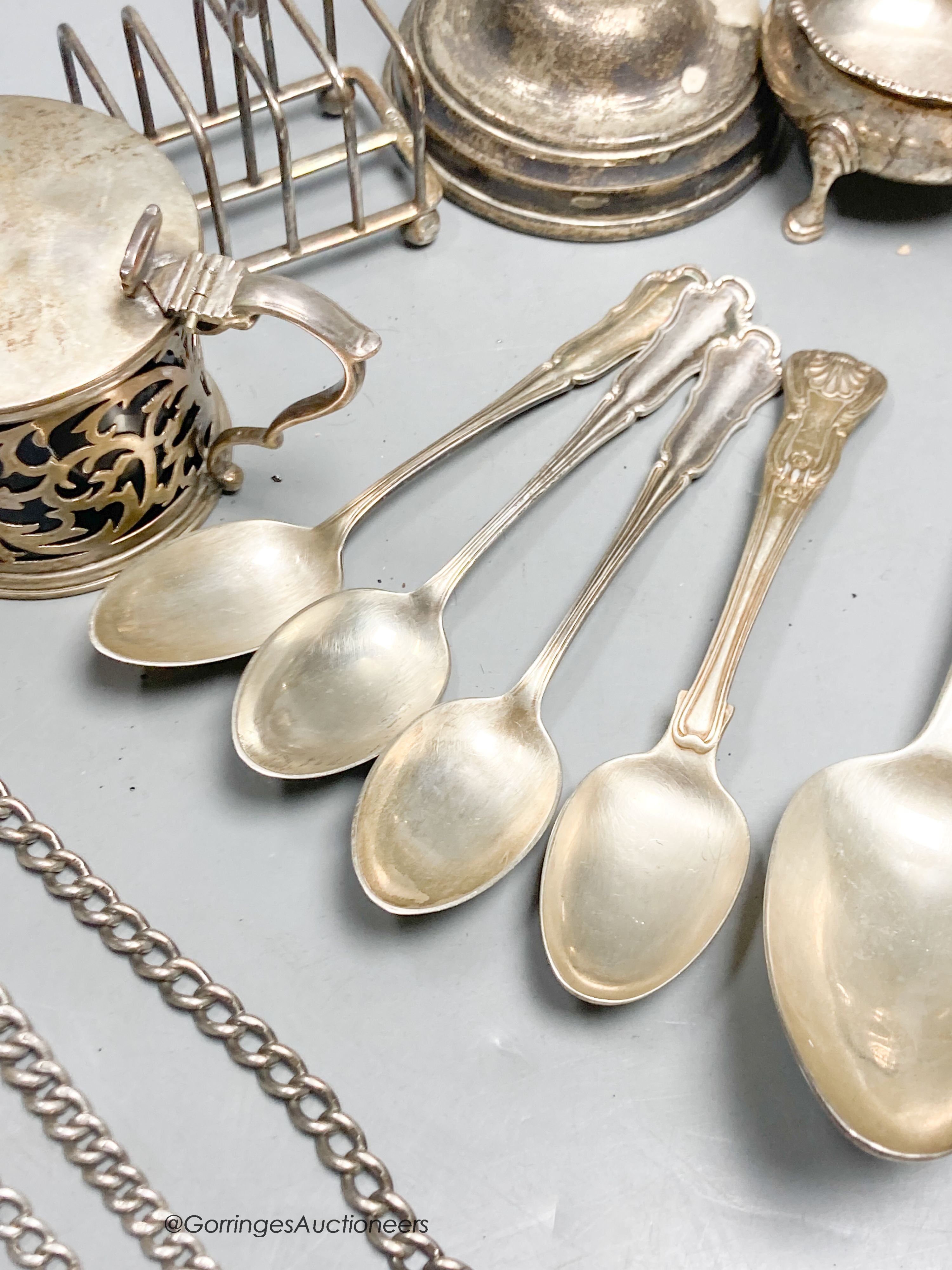 A collection of small silver, including a George V silver mustard, continental white metal and English silver flatware, toastrack, salt, inkwell etc. and a plated candlestick.